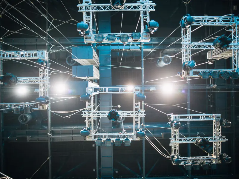 Steel lighting trusses with moving lights and speakers hanging above a stage